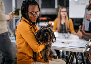 woman cuddling dog in the office