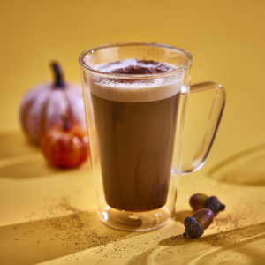 glass of pumpkin spiced latte on yellow background
