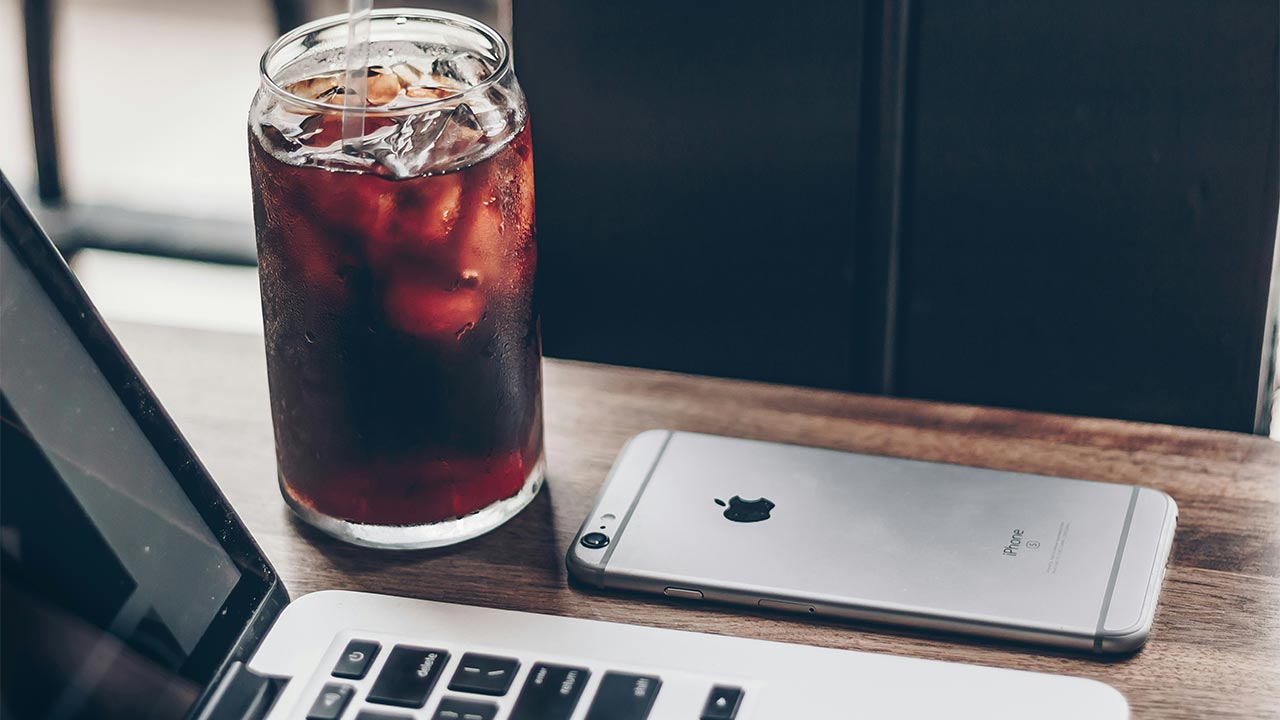 cold brew next to laptop and iphone