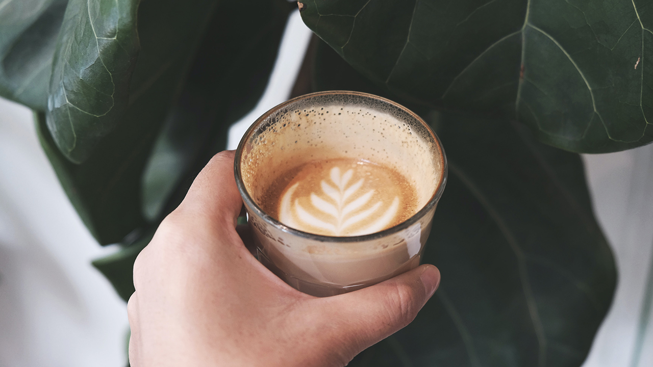 hand holding oat milk coffee