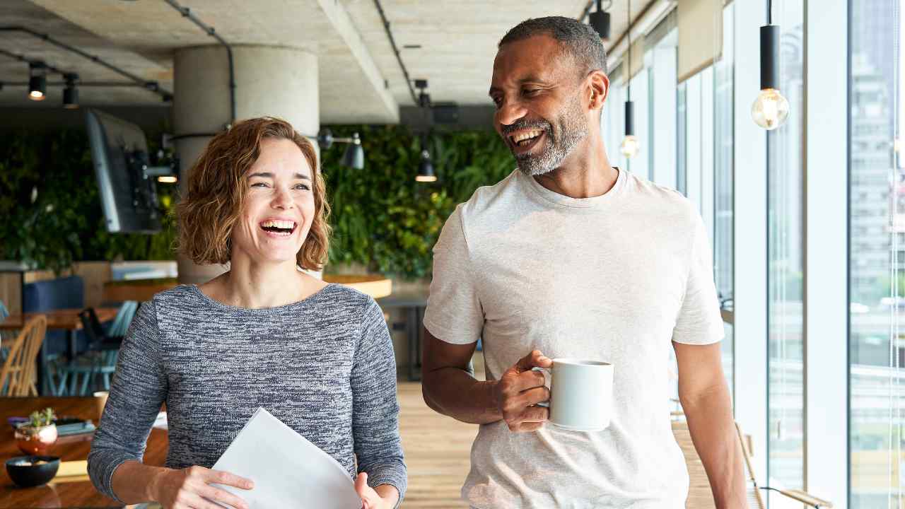 man and woman walking with coffee