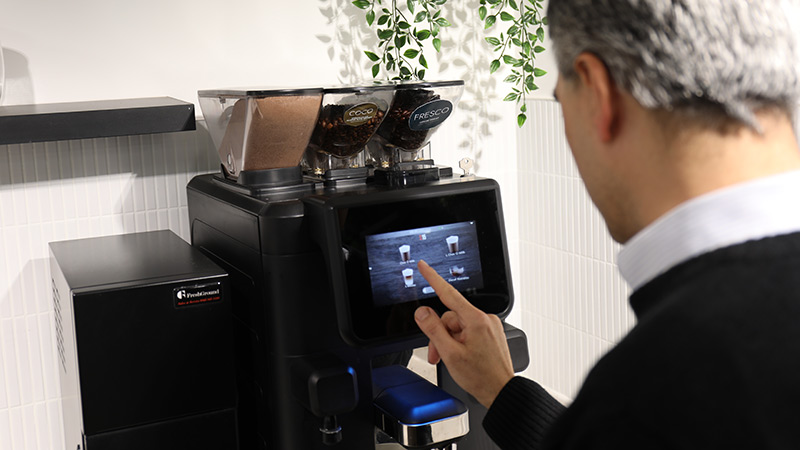 Person using a bean to cup coffee machine
